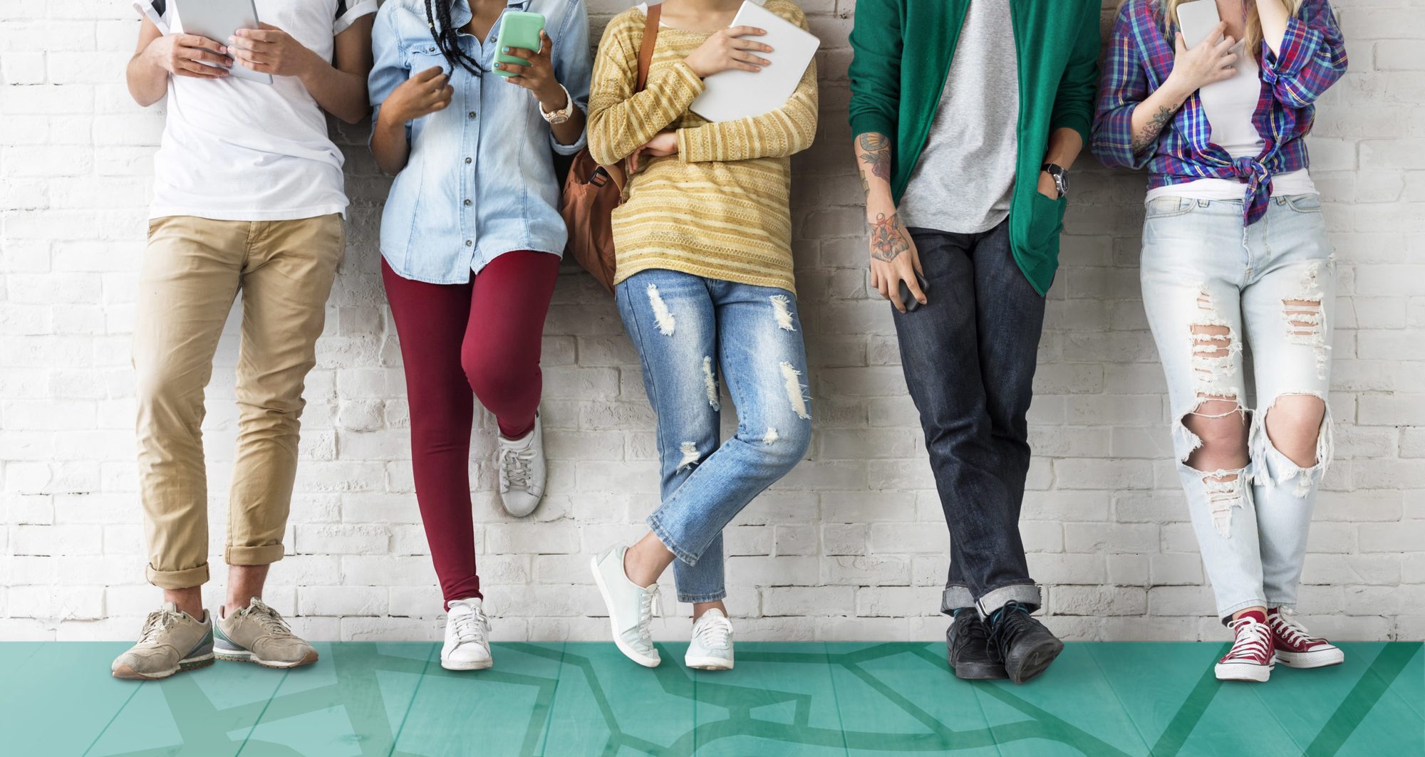 A group of teenagers leaning against a wall