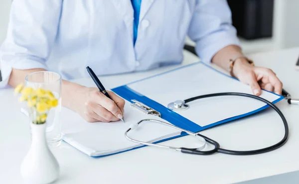 A doctor writing up notes from a consultation